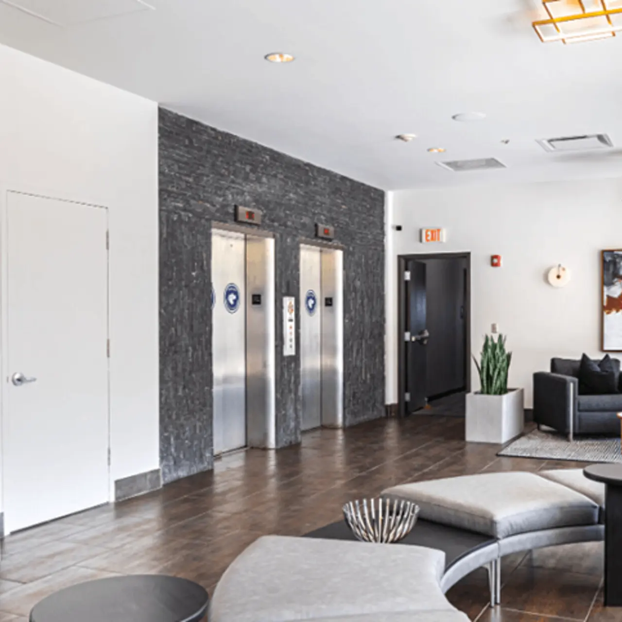 Modern Lobby Design A modern lobby area featuring elevators, seating, plants, and decorative art.