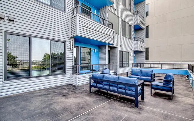 Outdoor patio area with blue furniture in a modern apartment complex