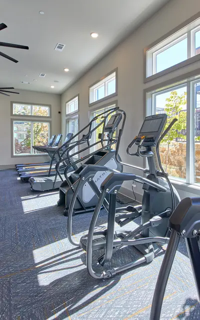 A bright and spacious gym interior featuring exercise equipment.