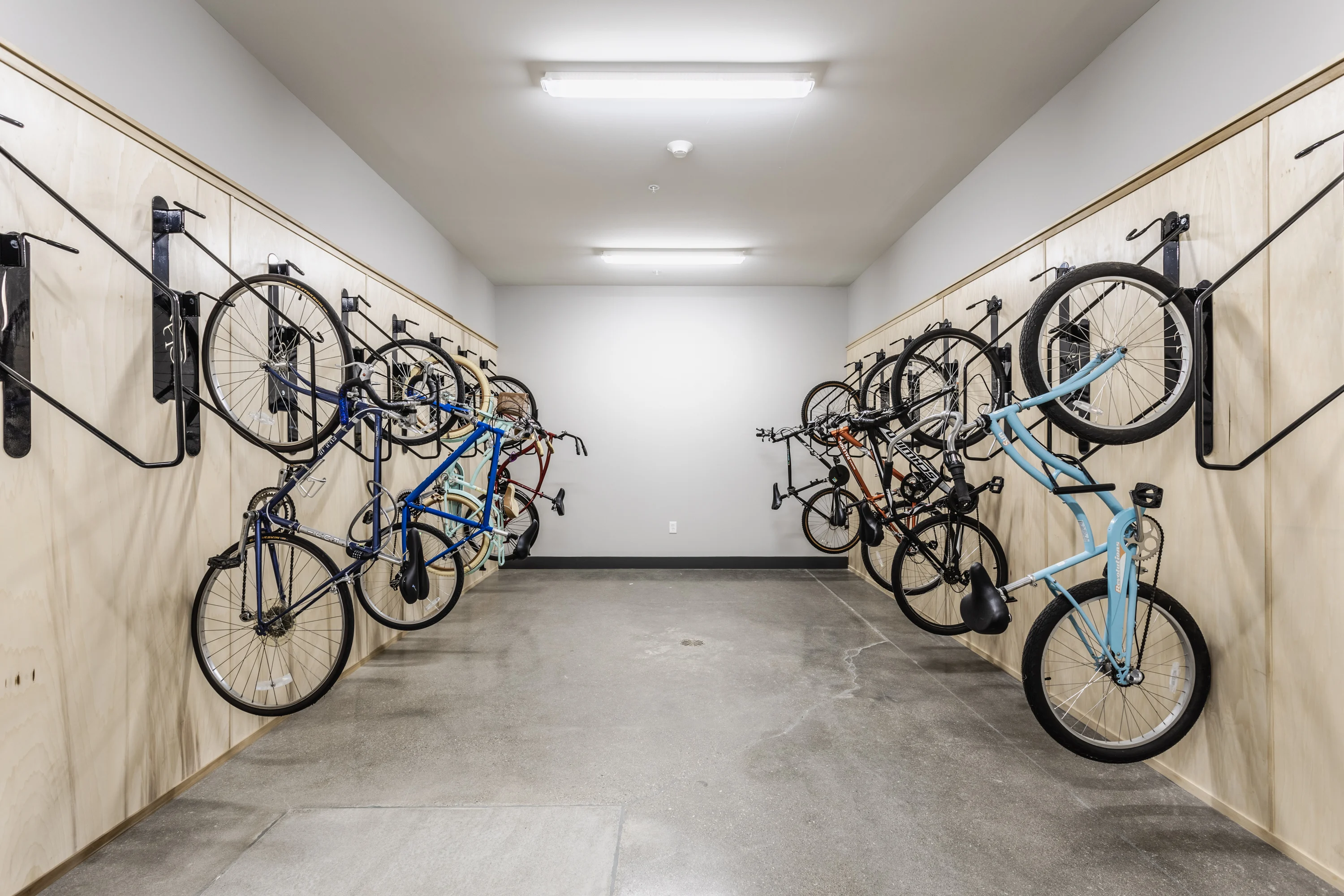 Indoor Bike Storage Area An indoor bike storage area displaying several bikes mounted on wooden wall racks.