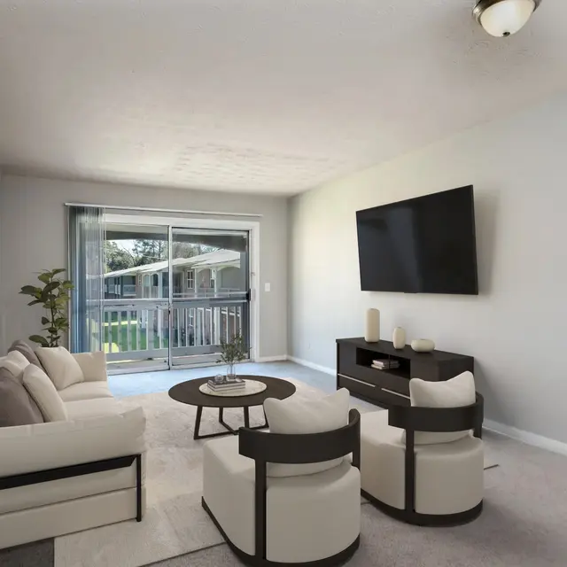 Stylish Modern Living Room A spacious living room with carpet flooring near double sliding glass doors leading to a private balcony.