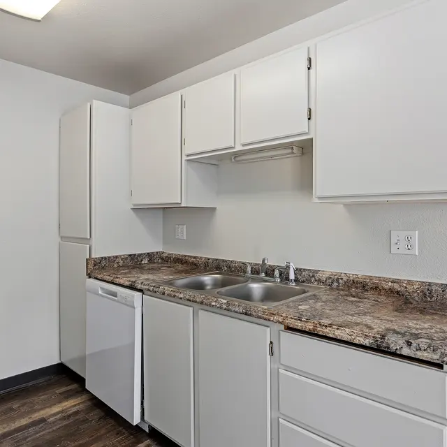 Modern Kitchen Design A modern kitchen featuring white cabinetry, a granite countertop, stainless steel sink, and a dishwasher.