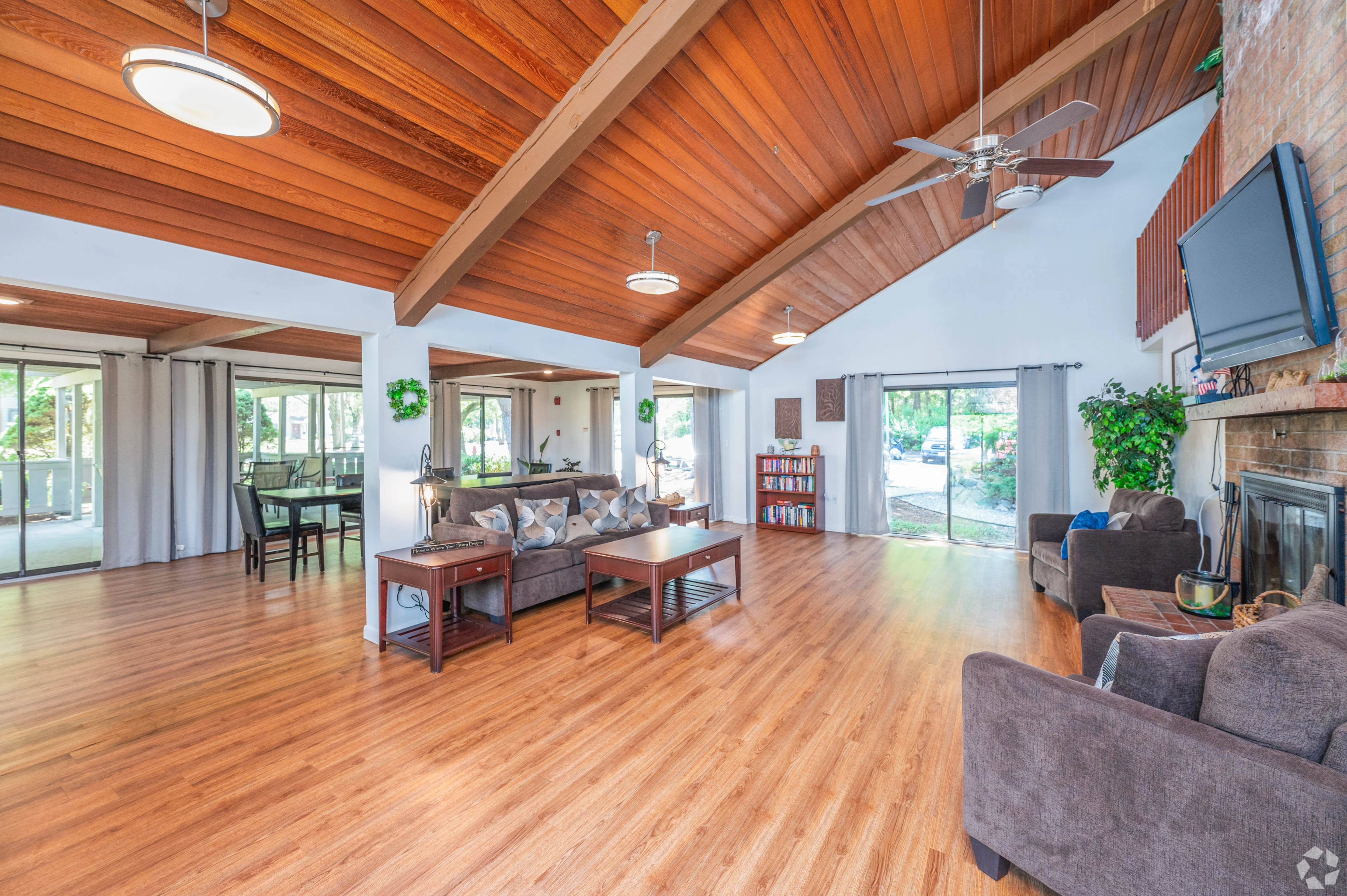 Spacious Living Room Design Bright and airy living room featuring wooden ceiling beams, large windows, and open layout with furniture including sofas and coffee tables.