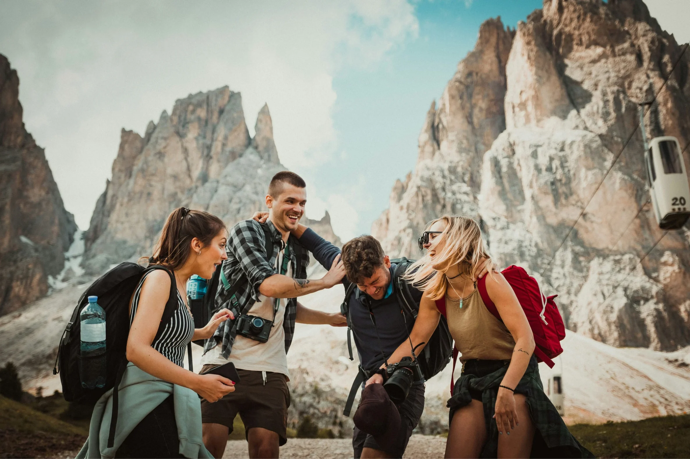 Adventure with Friends in the Mountains A group of five friends laughing and having fun outdoors in the mountains, wearing backpacks and casual clothing.