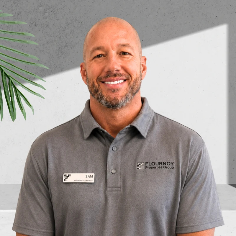 Real Estate Professional Smiling man wearing a gray polo shirt with a name tag