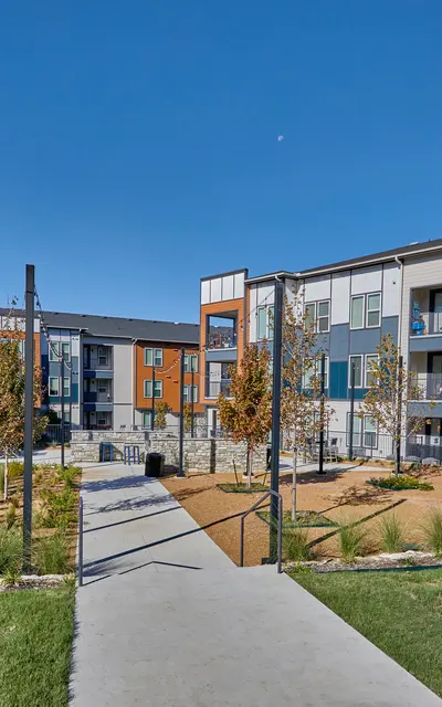 View of a modern apartment complex with a landscaped courtyard.
