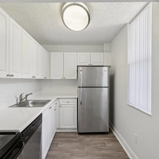 A modern kitchen featuring white cabinets, stainless steel appliances, and a clean countertop space with a sink.