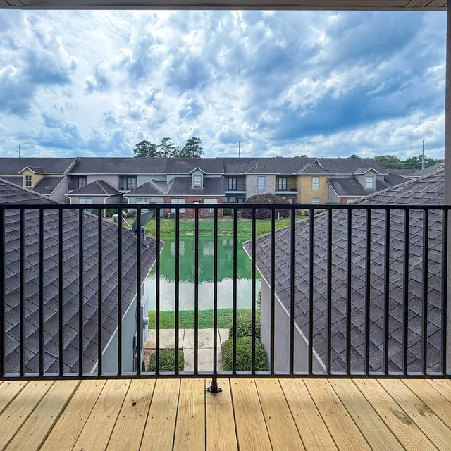 View from a balcony overlooking a small lake surrounded by buildings.