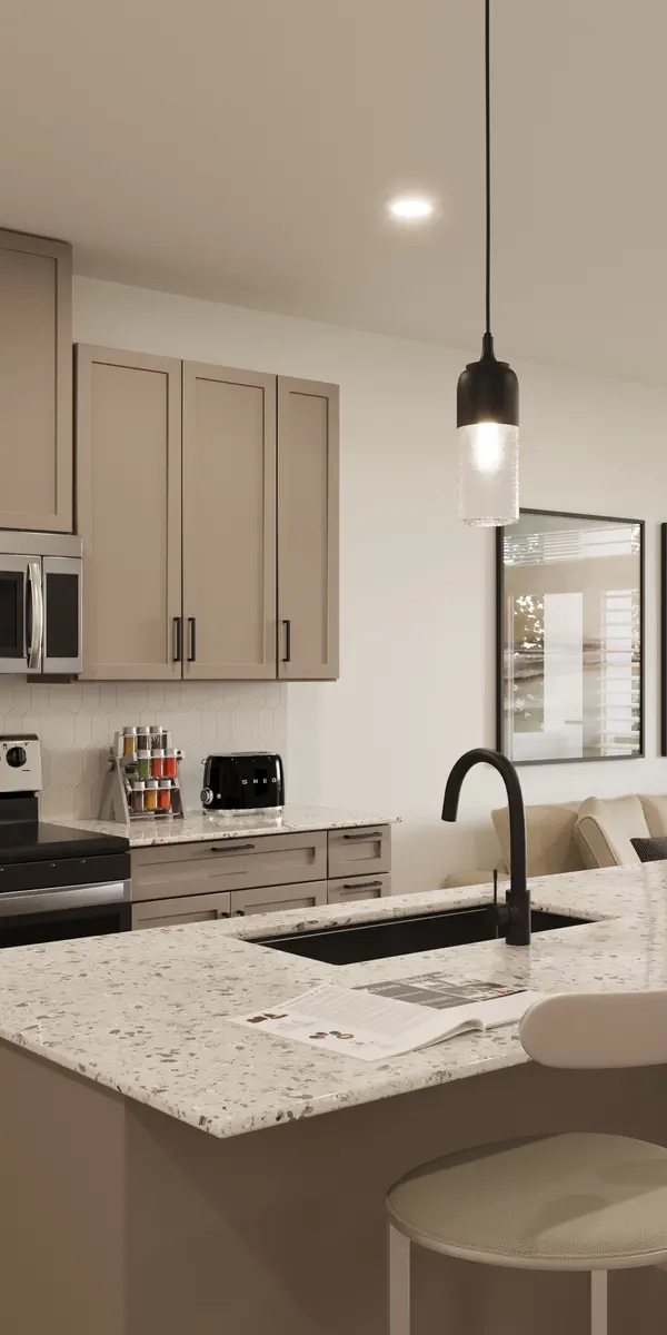 Modern Kitchen and Living Room Design A modern kitchen with light cabinets, granite countertops, and stainless steel appliances, connected to a cozy living room featuring a couch and coffee table.