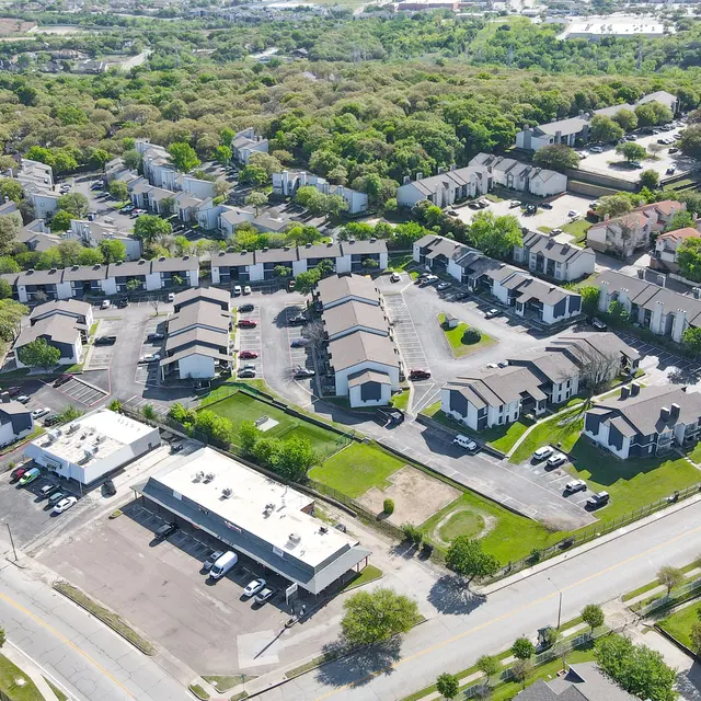 Aerial view of a residential area featuring multiple buildings and green spaces.