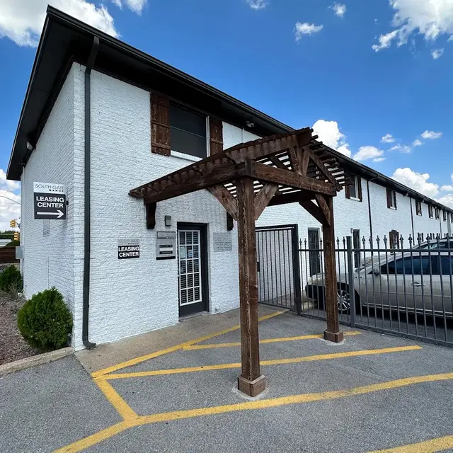 Learning Center Exterior Exterior view of a learning center building with a wooden awning and fenced parking area.