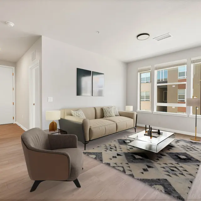 Modern Living Room Design A modern living room featuring a comfortable light beige sofa, a stylish armchair, and a coffee table on a patterned rug. Large windows allow natural light to brighten the room, and a television is placed on a wooden console.