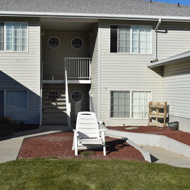 Apartment Exterior View Exterior view of an apartment building with stairs leading up, surrounded by landscaped areas and a lawn.