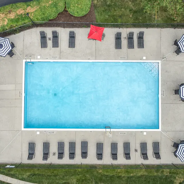 Aerial view of a swimming pool surrounded by lounge chairs and umbrellas.