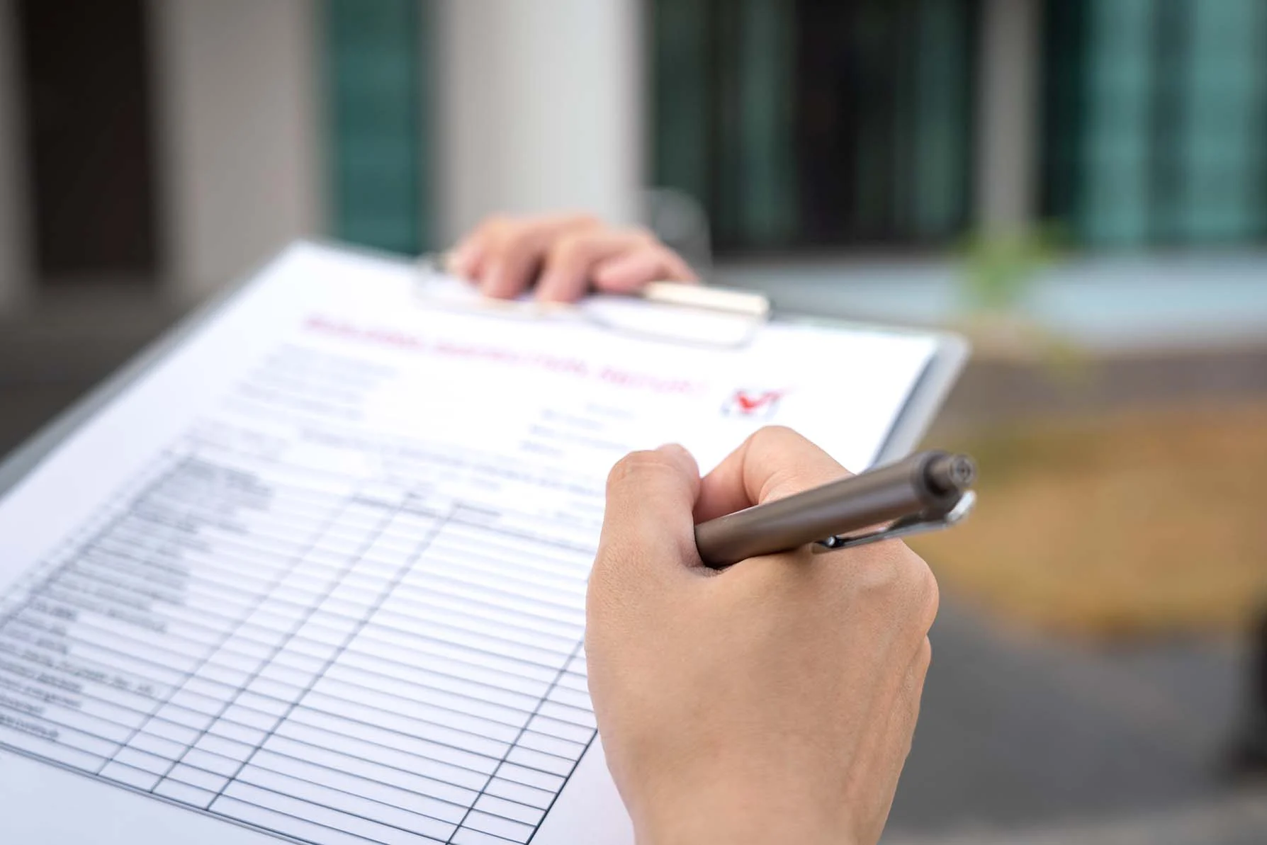 Person Filling Out Checklist A close-up of a person's hand holding a clipboard with a checklist and a pen, ready to jot down information.