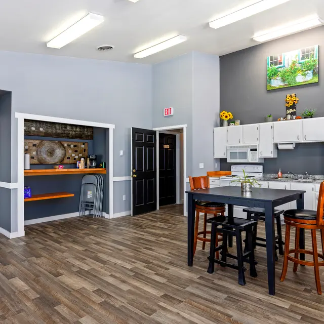 Modern Kitchen Interior Interior view of a spacious kitchen with wooden flooring, modern appliances, and a central dining table.