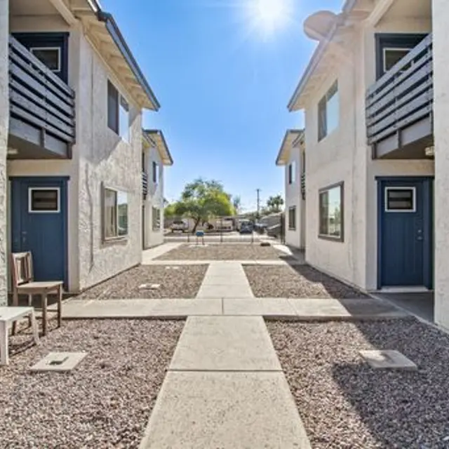View of a courtyard in an apartment complex with two-story buildings and pathways leading between them.