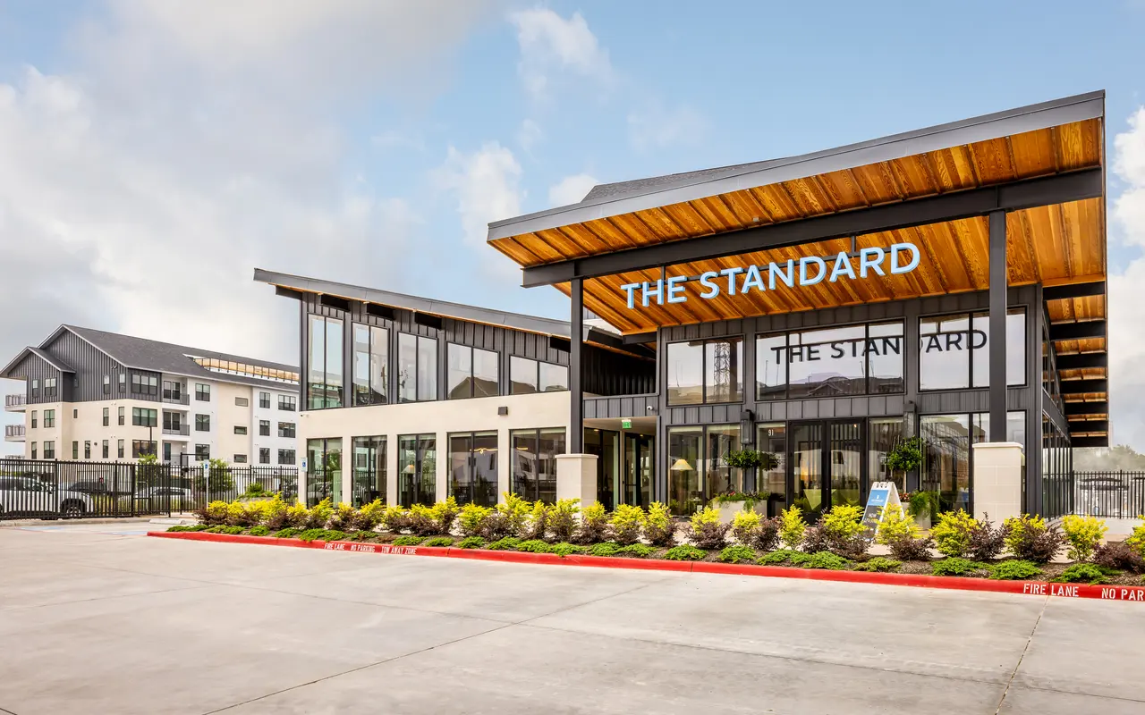 Exterior of Standard on the River leasing office with plants and lush greenery.