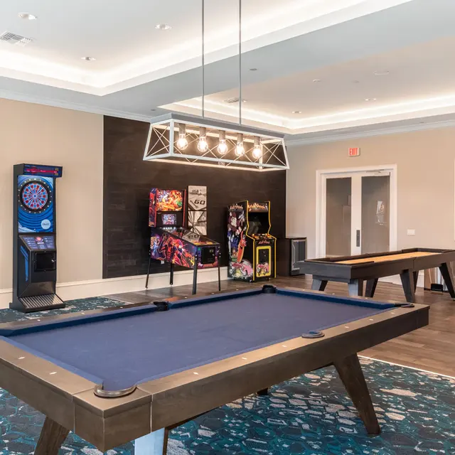 clubhouse game room with pool table, darts, and arcade games
