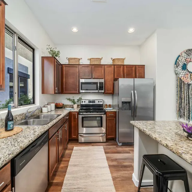 Modern kitchen with granite countertops and stainless steel appliances at Avilla Marana