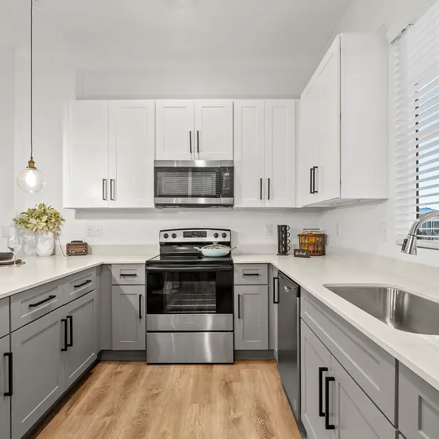 Gourmet kitchen with gray cabinetry and stainless steel appliances at The Farmhouse on Estrella