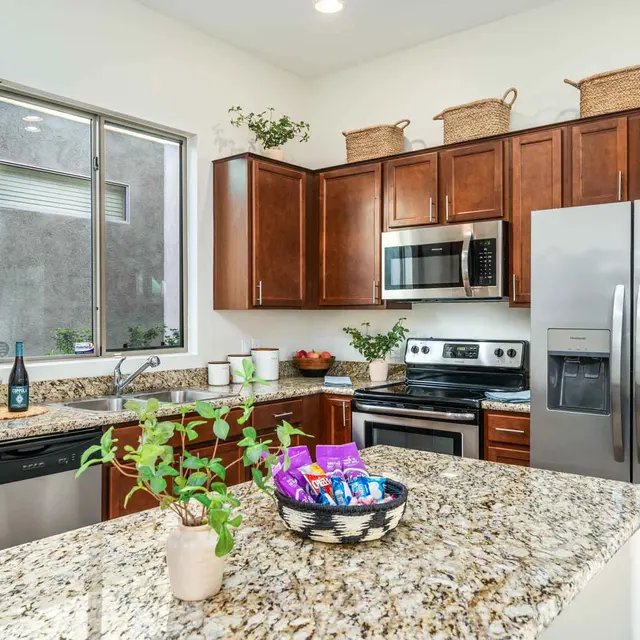 Modern kitchen with stainless steel appliances and granite countertops at Avilla Marana