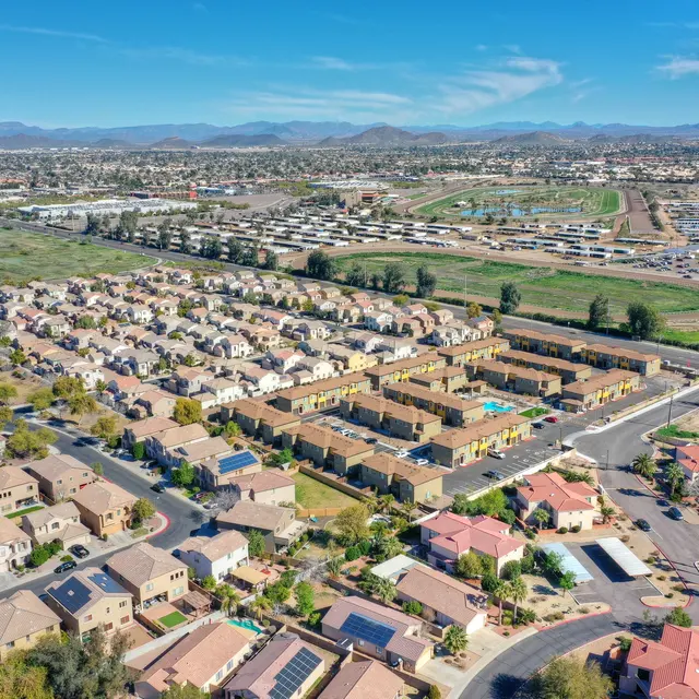 Aerial View of Residential Community An aerial view of a residential community featuring rows of homes with green spaces and roads.