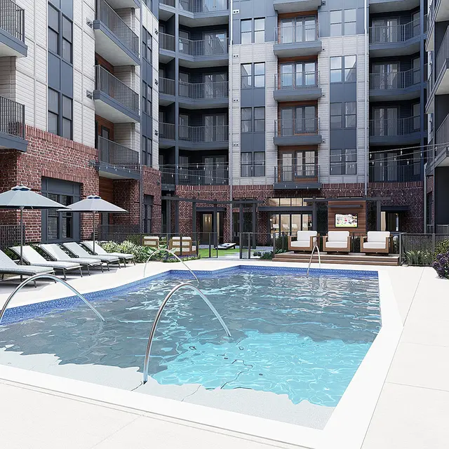 A modern apartment complex featuring a swimming pool with lounge chairs and umbrellas. Surrounding the pool are plants and buildings that have a mix of brick and contemporary design.