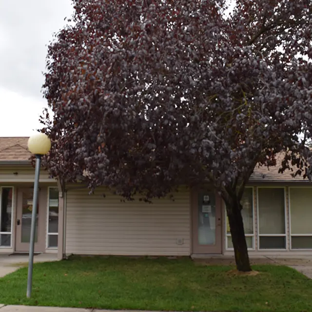 House with Purple-Leaved Tree Exterior view of a house with a large purple-leaved tree in front.