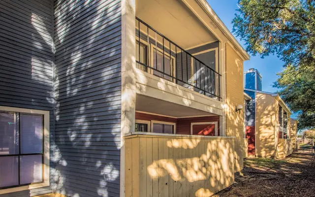 Exterior view of a multi-story apartment building showcasing modern design elements and well-maintained surroundings.