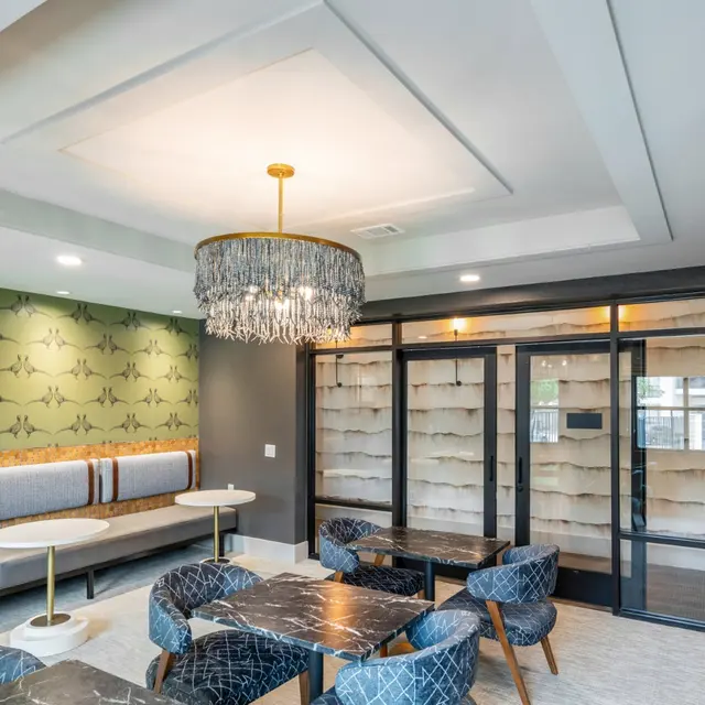 A modern living area featuring stylish seating, a chandelier, and elegant decor.