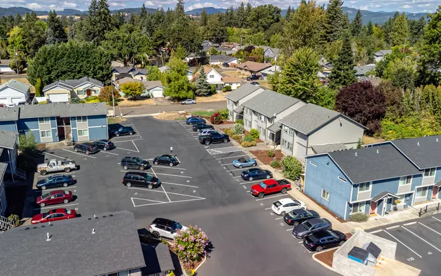 Aerial view of a residential apartment complex with multiple parked cars.
