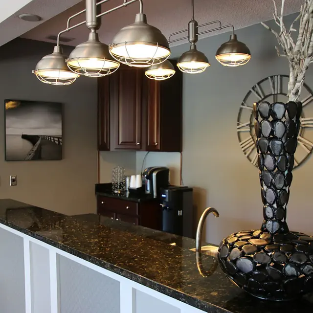 The kitchen island countertop with lighting hanging over from the ceiling for proper lighting. 