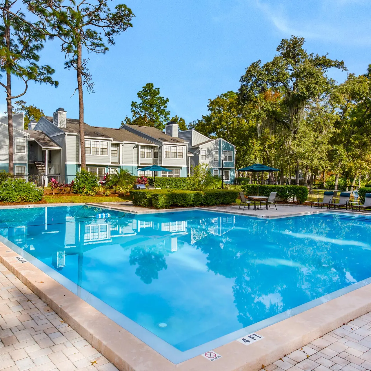 large swimming pool with lounge chairs surrounding