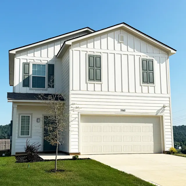 A modern two-story house with a white exterior and green window shutters, featuring a garage and well-maintained lawn.