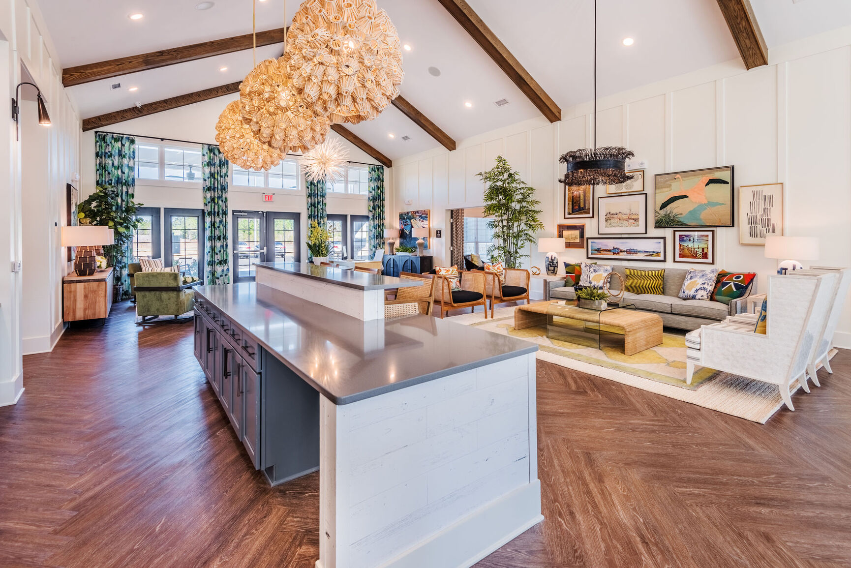 Contemporary Living Room Interior A spacious modern living room with wooden beams, large windows, and stylish furnishings. The room features a kitchen island, green plants, and decorative lighting fixtures.