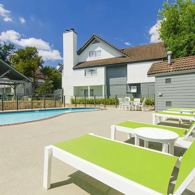 Lime green lounge chairs and patio chairs and table at resident pool at Edge Studios