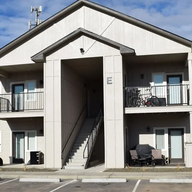 Modern Apartment Building Front view of a two-story apartment building with a central entrance and balconies.