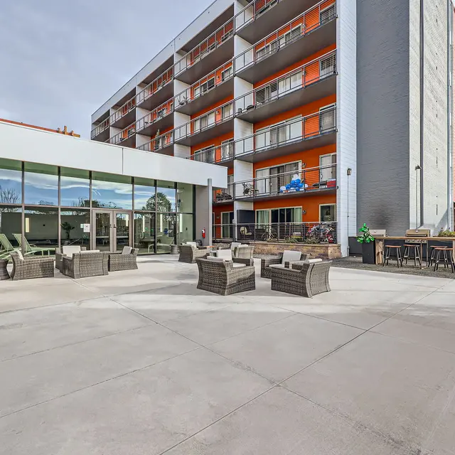 Outdoor area with modern seating and a building in the background.