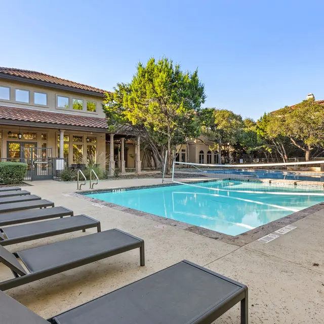 Swimming pool area with lounge chairs and a surrounding patio