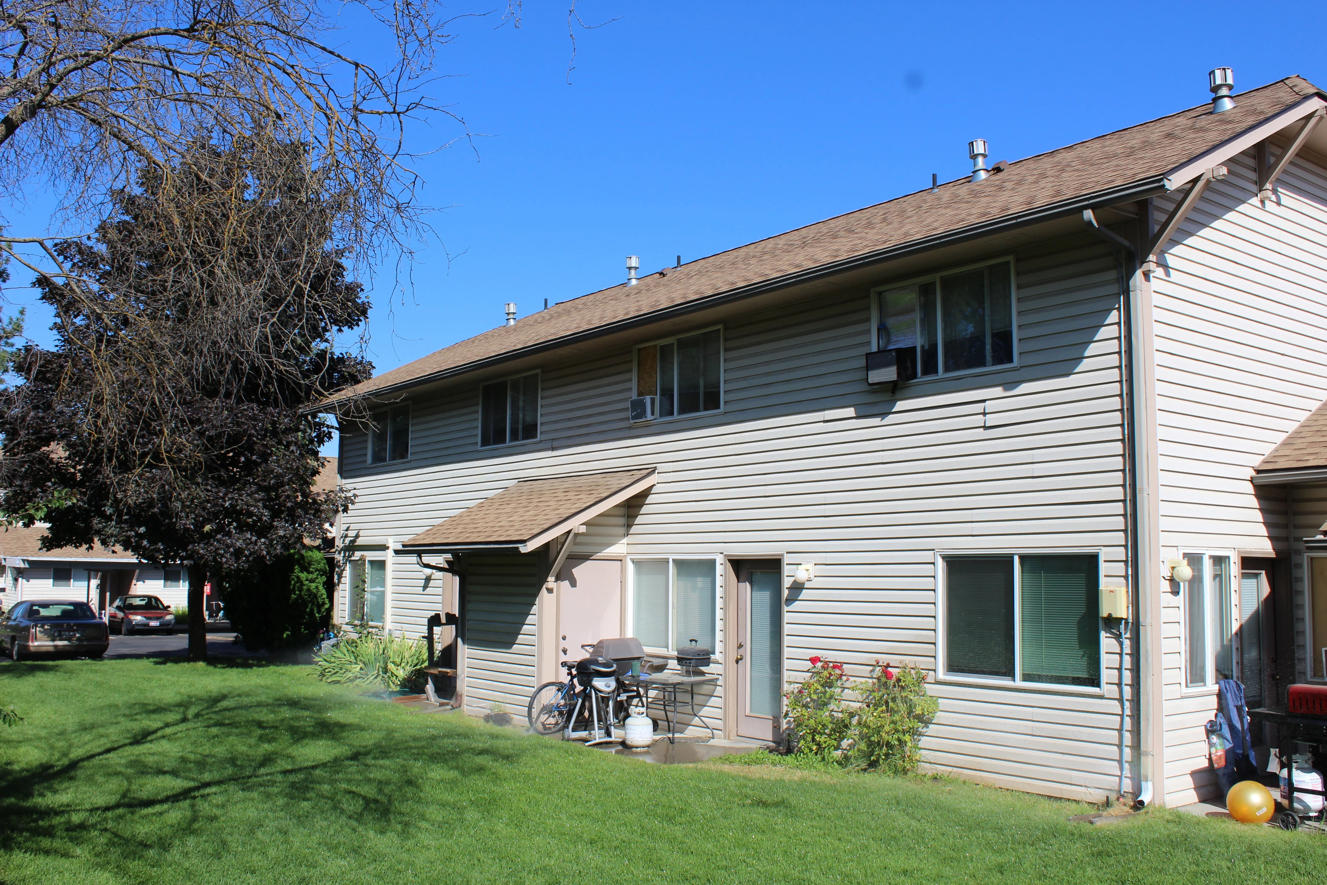 Exterior view of a two-story residential building with a grassy area in front.