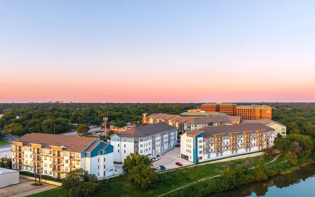 A serene sunset view over a modern apartment complex reflecting the tranquility of urban living alongside nature.