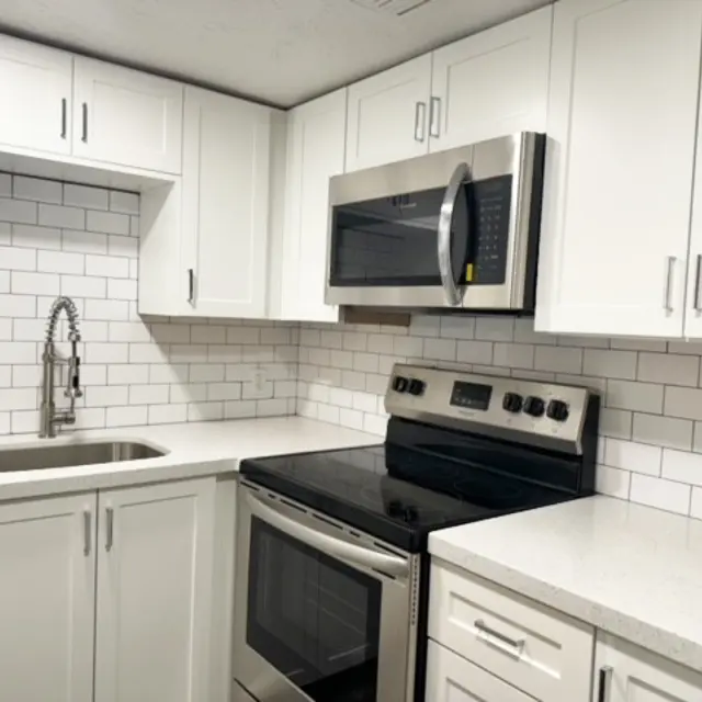 A modern kitchen featuring white cabinetry, stainless steel appliances, and a subway tile backsplash.
