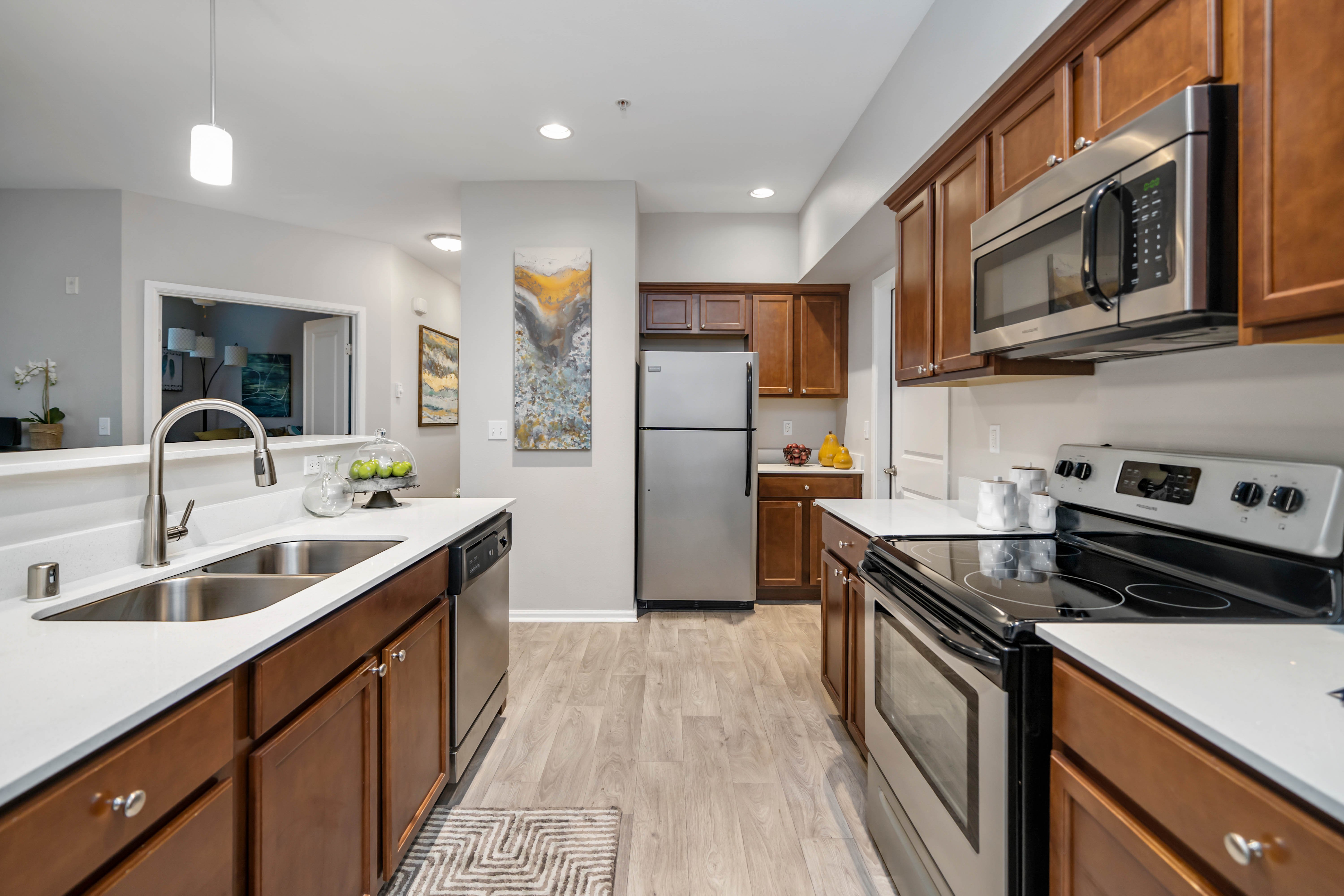 Modern Kitchen Design A modern kitchen featuring wooden cabinets, stainless steel appliances, and a spacious layout with a double sink and a decorative rug.