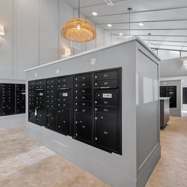 Modern Mailroom Design Interior view of a modern mailroom with multiple black mailboxes and a stylish light fixture.