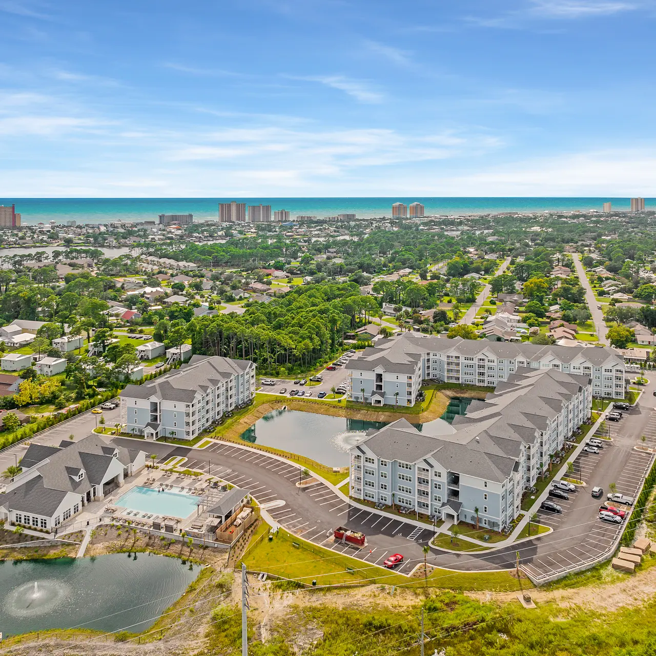 aerial view of apartment with ocean and city in the distance