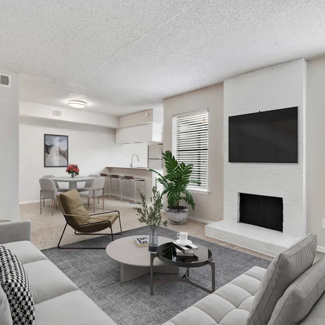 Carpeted living and dining area with view into kitchen and breakfast bar and fireplace in living room with central air and windows with natural lighting 