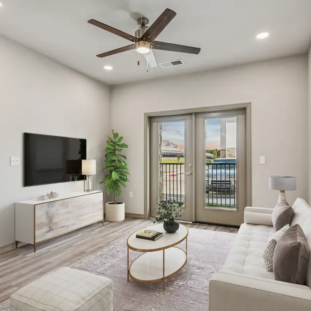 Modern Apartment Living Room A modern living room featuring a white sofa, round coffee table, and a TV on a light wooden cabinet. Large windows open to a balcony, with a potted plant in the corner and a decorative framed picture on the wall.
