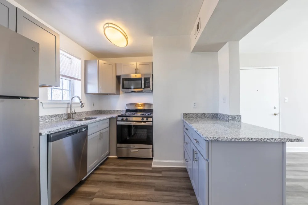 A modern kitchen featuring stainless steel appliances, granite countertops, and light-colored cabinetry.