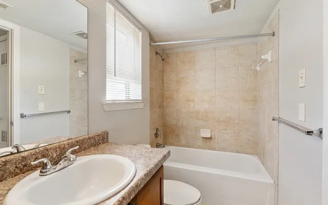 Modern Bathroom Interior A clean and modern bathroom featuring a bathtub, sink, and mirror with a light-colored tile backdrop.